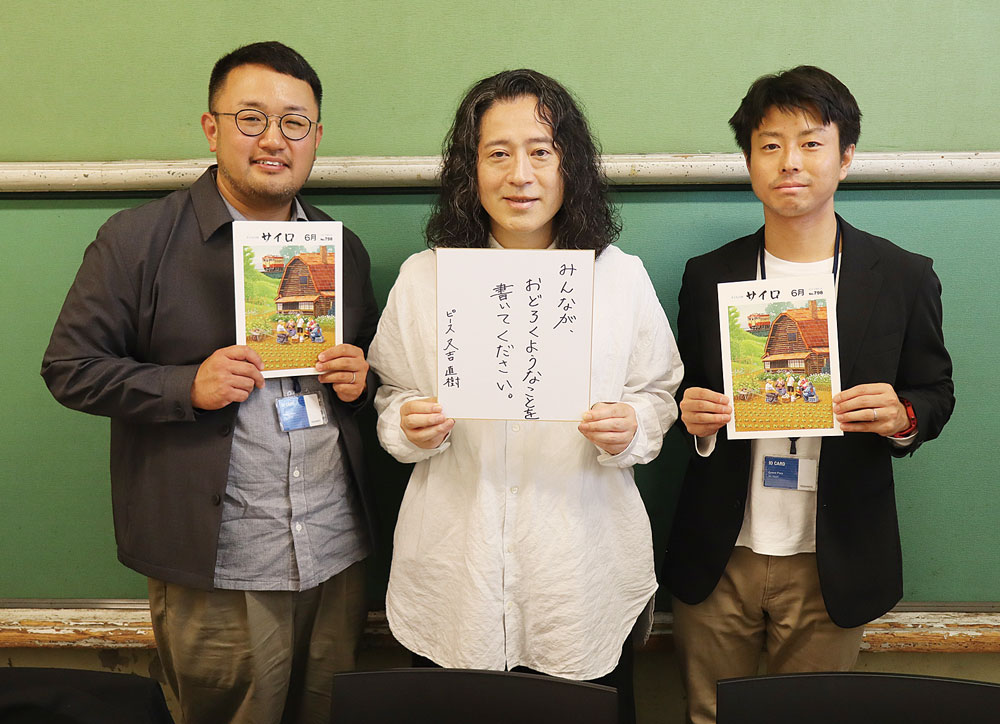 直筆のメッセージを手にする又吉さん（中央）と編集スタッフの稲船（左）、小野（右）